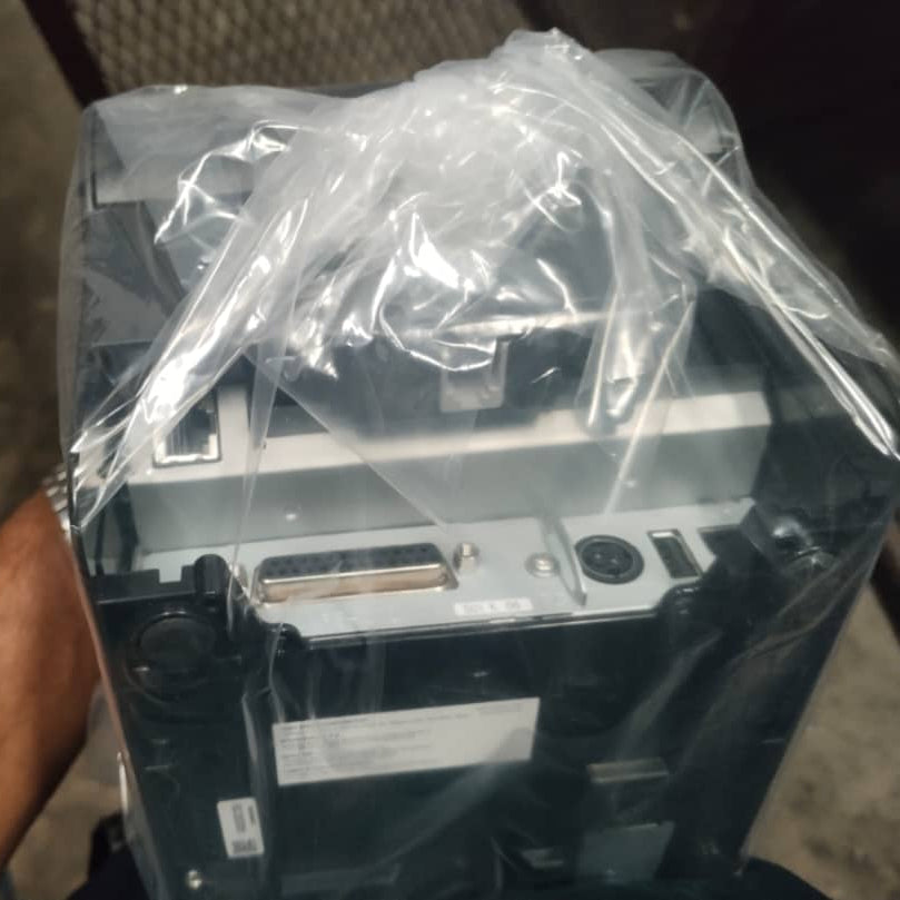Electrical component wrapped in plastic, held by a person with a blurred background