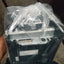 Electrical component wrapped in plastic, held by a person with a blurred background