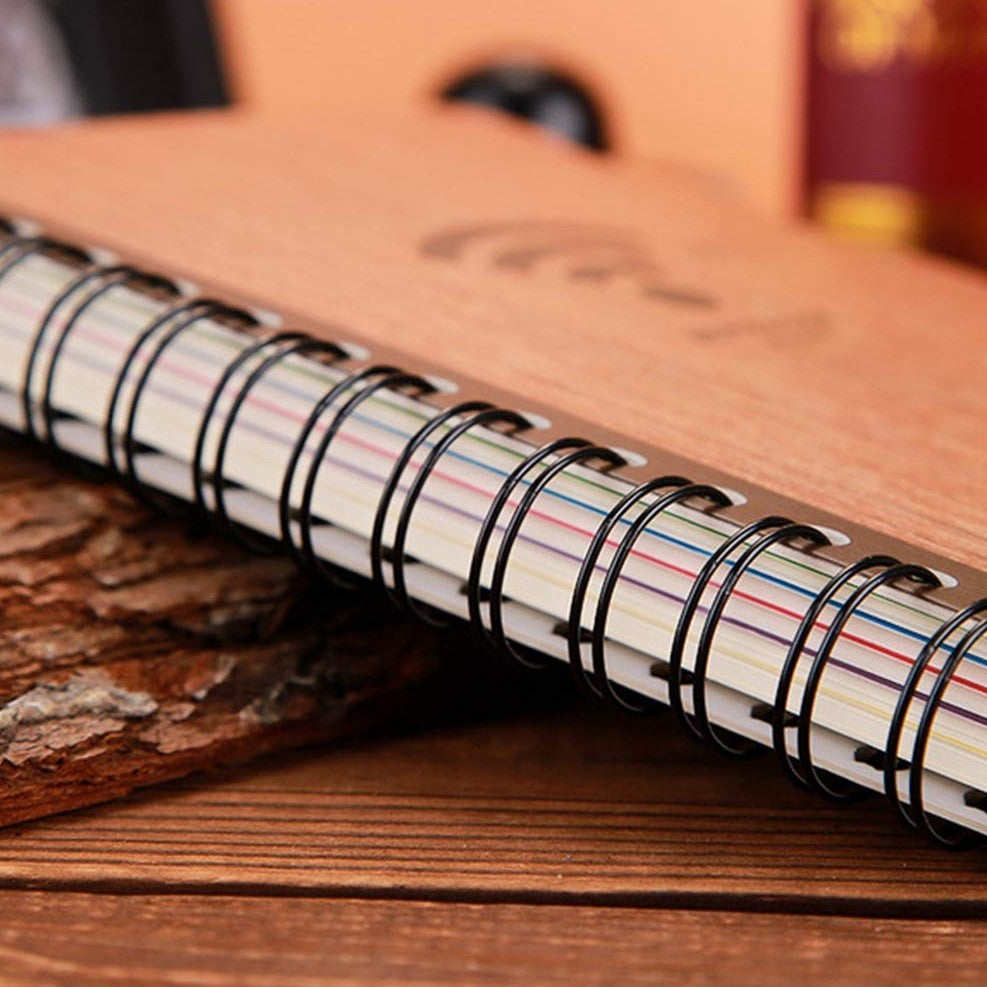 Notebook with wire binding on a wooden surface