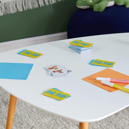 Colorful cards and markers on a white table with a green wall and toy in the background