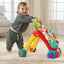 Child playing with a colorful toy walker in a living room.